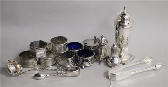 A collection of silver condiments, a sugar caster, napkin rings and sundries